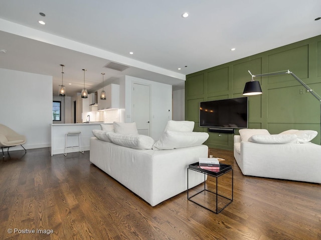 living room with dark hardwood / wood-style floors and sink