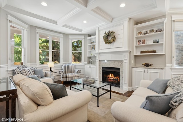 living room with a high end fireplace, ornamental molding, coffered ceiling, beamed ceiling, and light hardwood / wood-style floors