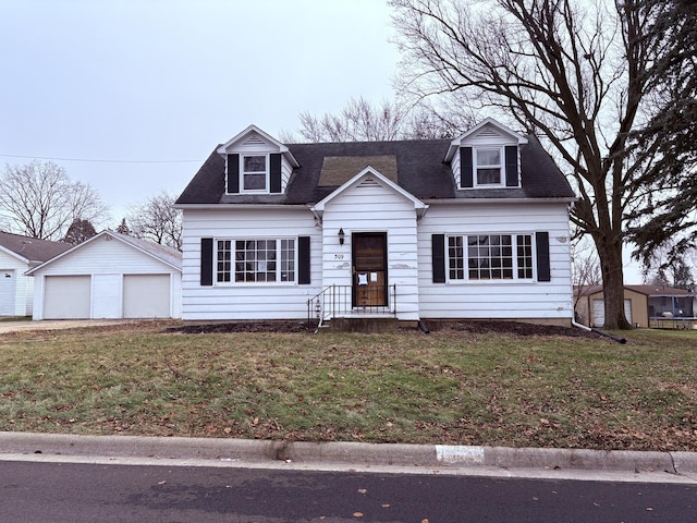 new england style home featuring a garage, an outdoor structure, and a front lawn