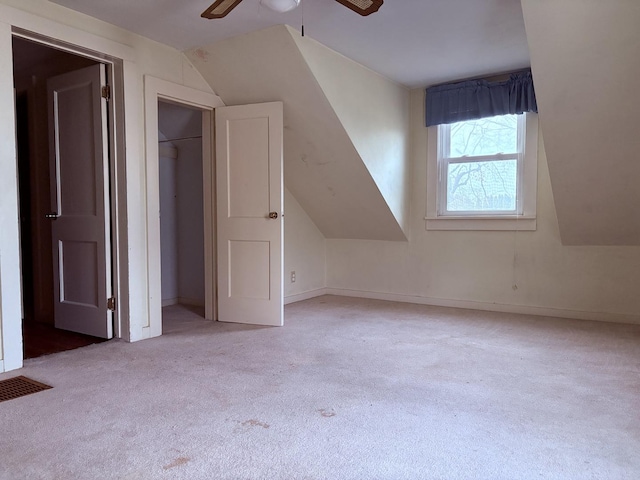 additional living space with ceiling fan, light colored carpet, and lofted ceiling