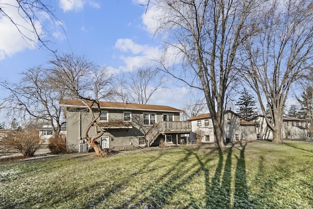 back of house featuring a wooden deck and a yard