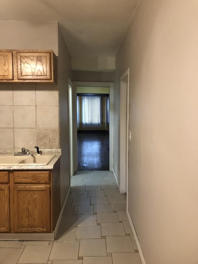 hall with light tile patterned floors and sink