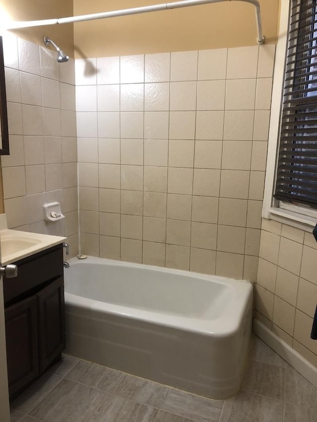 bathroom with tile patterned floors, vanity, tile walls, and bathing tub / shower combination