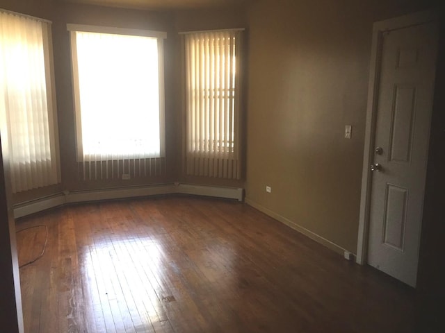 unfurnished room featuring dark hardwood / wood-style flooring and a baseboard radiator