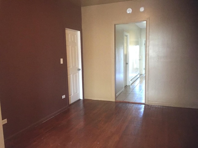 spare room featuring hardwood / wood-style floors and a baseboard radiator