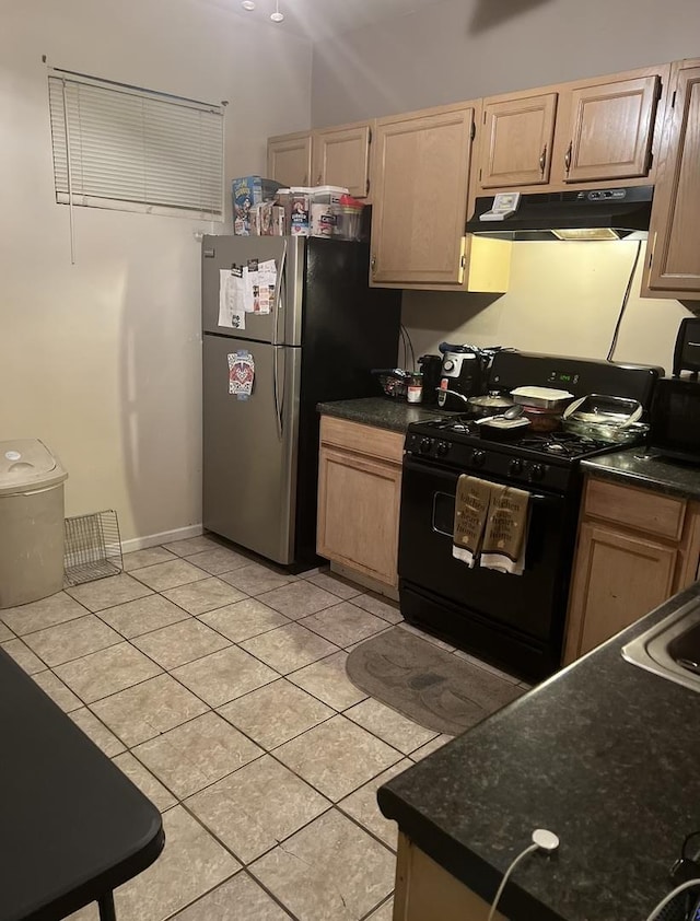 kitchen with stainless steel refrigerator, black range with gas stovetop, light brown cabinets, and light tile patterned flooring