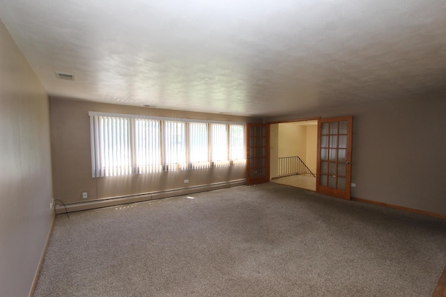 carpeted spare room featuring french doors and a baseboard radiator