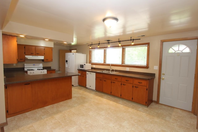 kitchen with kitchen peninsula, white appliances, and sink