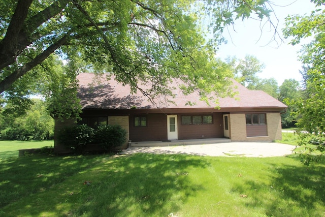 back of house with a lawn and a patio