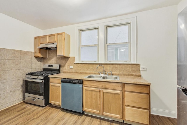 kitchen featuring appliances with stainless steel finishes, light wood-type flooring, light brown cabinets, and sink