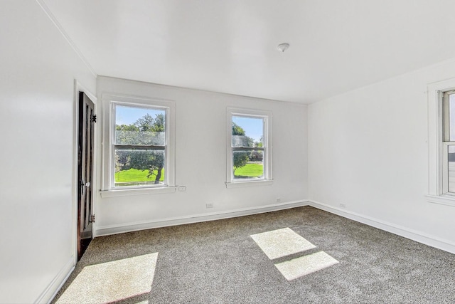 carpeted spare room featuring a healthy amount of sunlight