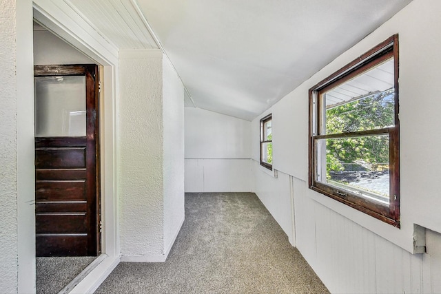 corridor featuring carpet flooring and vaulted ceiling