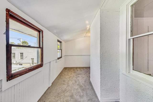 hallway featuring light carpet and lofted ceiling