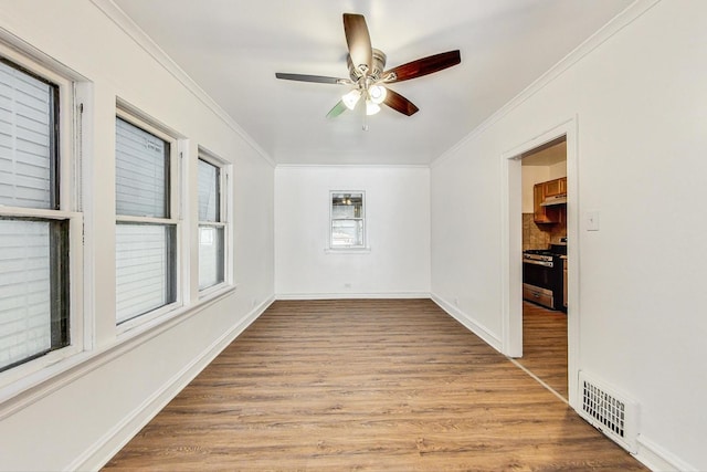 empty room with light hardwood / wood-style flooring, ceiling fan, and ornamental molding