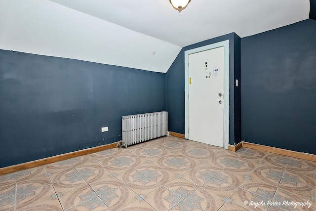 additional living space with tile patterned floors, radiator heating unit, and vaulted ceiling