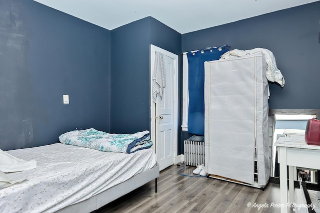 bedroom with hardwood / wood-style flooring and radiator