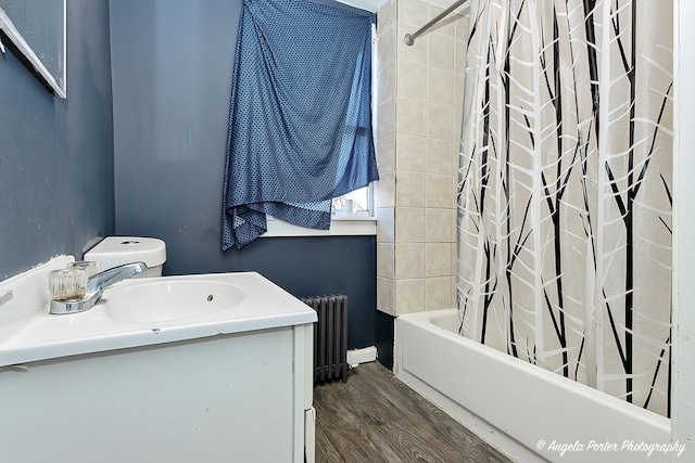 bathroom with radiator heating unit, vanity, hardwood / wood-style floors, and shower / tub combo with curtain