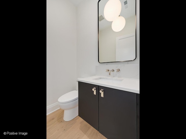 bathroom featuring hardwood / wood-style floors, vanity, and toilet