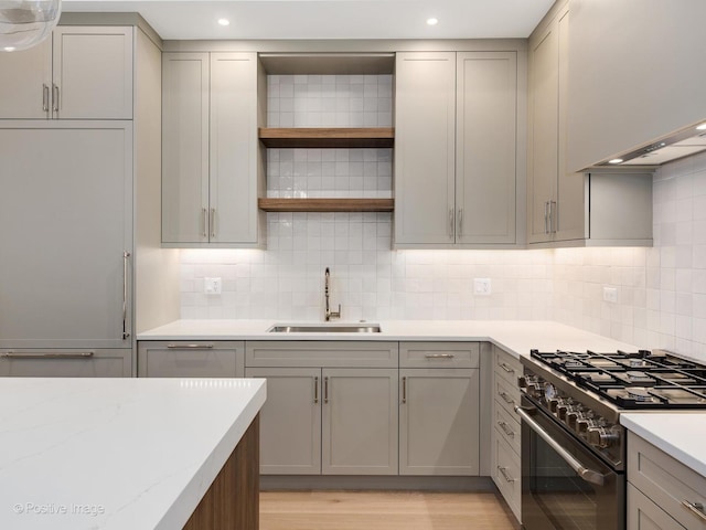 kitchen with gray cabinetry, refrigerator, sink, decorative backsplash, and stainless steel range