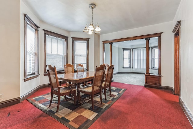 carpeted dining space featuring a notable chandelier