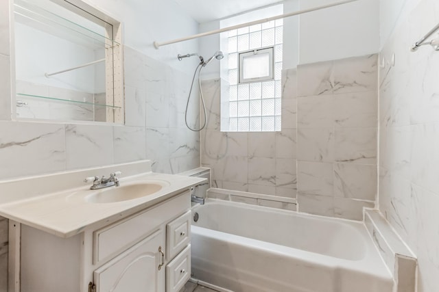 bathroom featuring vanity, tiled shower / bath, and tile walls