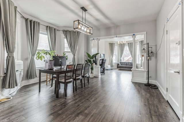 dining space with plenty of natural light, dark hardwood / wood-style flooring, and an inviting chandelier