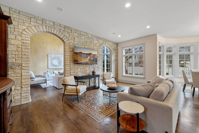 living room with a fireplace and dark wood-type flooring