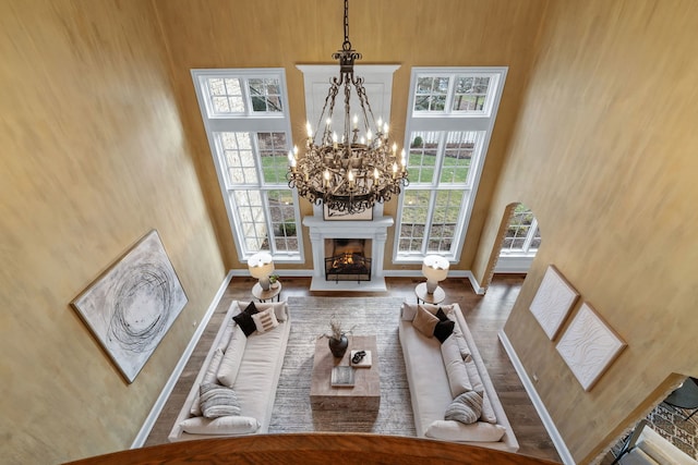 living room with hardwood / wood-style floors, a chandelier, and a high ceiling