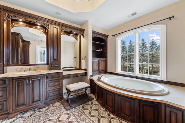 bathroom featuring built in shelves, vanity, tile patterned floors, and a bathing tub