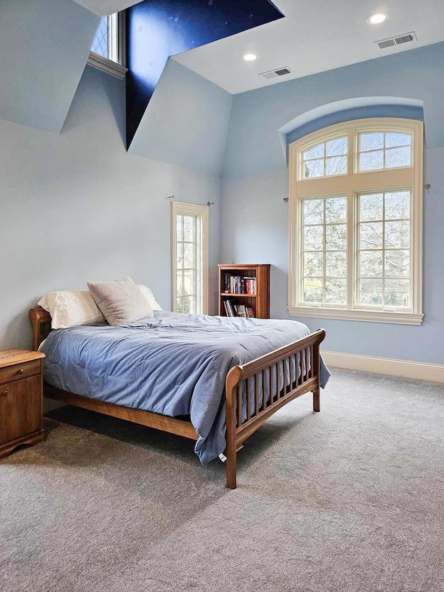 carpeted bedroom featuring multiple windows and vaulted ceiling