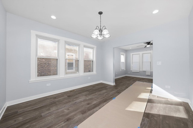 unfurnished dining area with ceiling fan with notable chandelier and dark hardwood / wood-style flooring