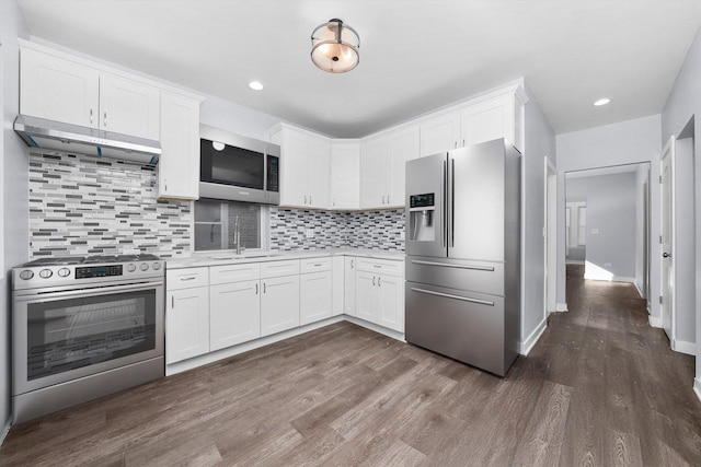 kitchen featuring white cabinets, sink, stainless steel appliances, and extractor fan