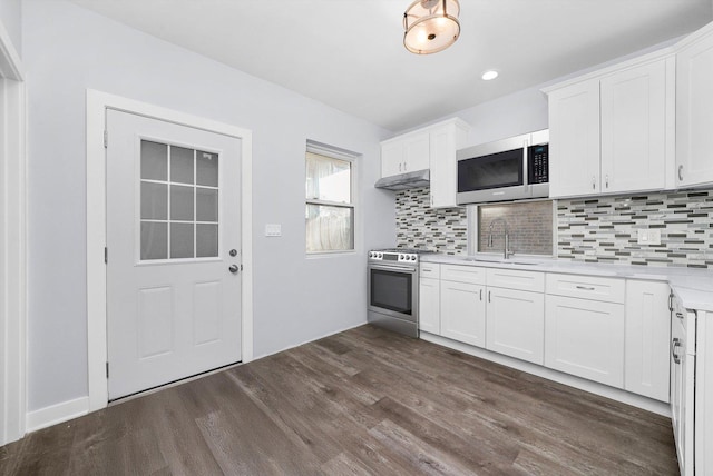 kitchen featuring backsplash, white cabinets, sink, dark hardwood / wood-style flooring, and stainless steel appliances