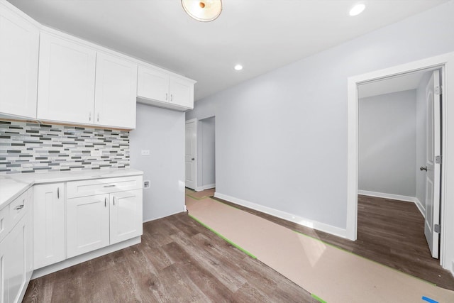 kitchen with white cabinets, backsplash, hardwood / wood-style flooring, and light stone countertops