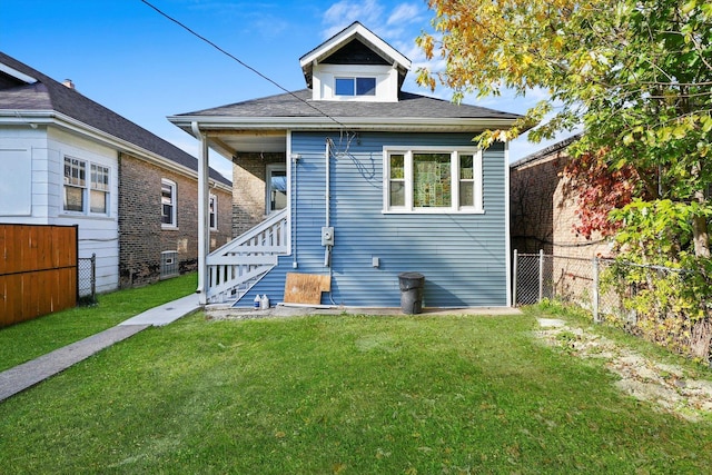 rear view of property featuring a lawn