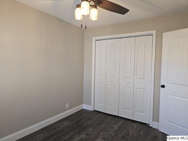 unfurnished bedroom with ceiling fan, dark hardwood / wood-style floors, and a closet