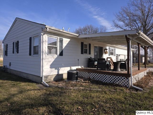 back of property with a yard and a deck