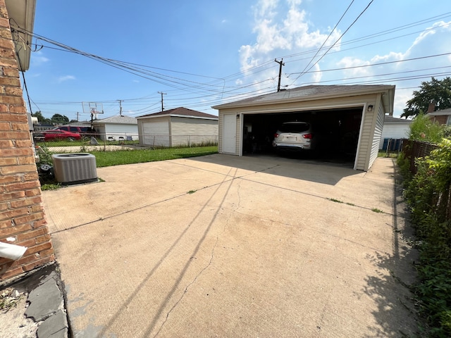 garage featuring a lawn and central AC unit