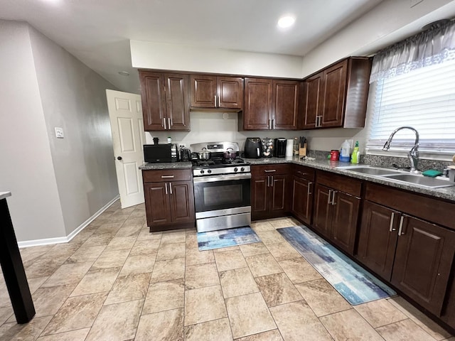 kitchen featuring dark brown cabinetry, sink, and stainless steel stove