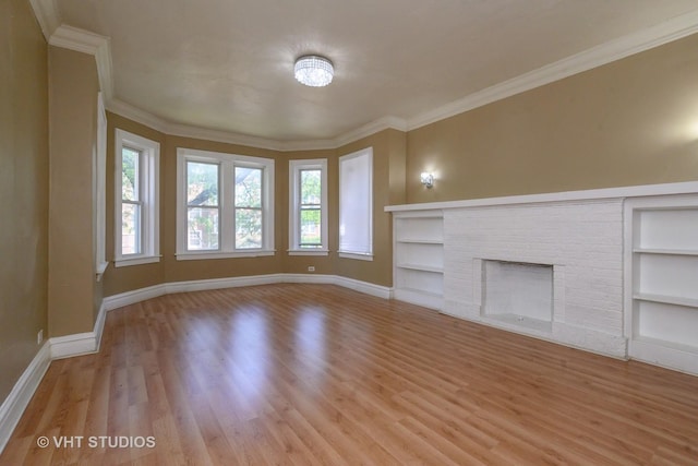 unfurnished living room featuring a brick fireplace, light hardwood / wood-style floors, built in features, and crown molding