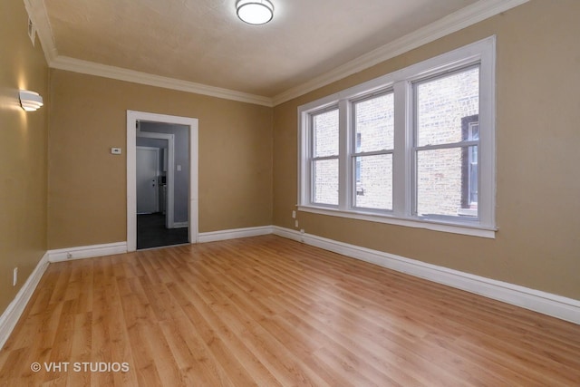 spare room with plenty of natural light, light wood-type flooring, and ornamental molding