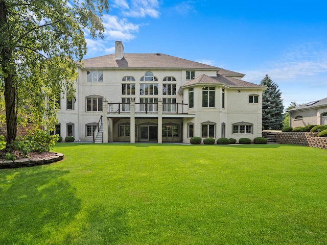 rear view of house with a yard and a deck