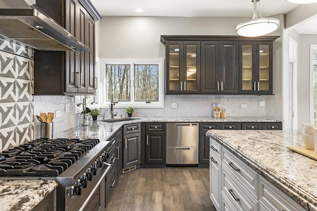 kitchen with wall chimney range hood, stovetop, dark hardwood / wood-style floors, white cabinets, and stainless steel dishwasher