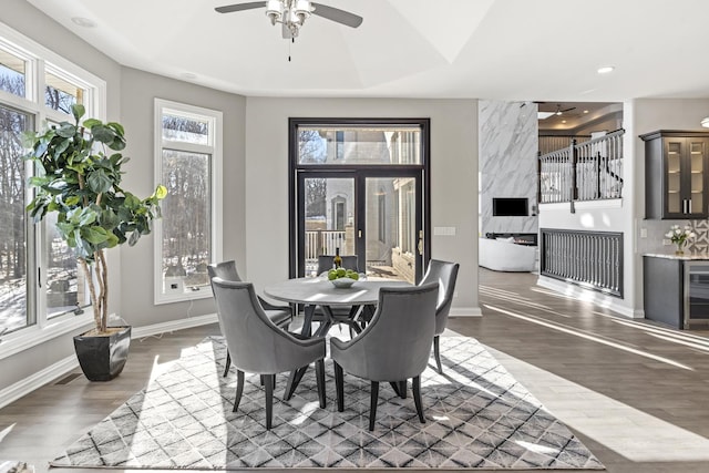 dining space with ceiling fan, dark hardwood / wood-style flooring, and french doors