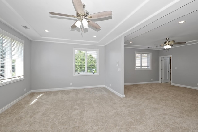 empty room featuring crown molding, light colored carpet, and ceiling fan