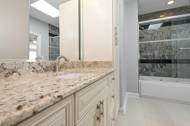 bathroom with tile patterned flooring, enclosed tub / shower combo, and vanity