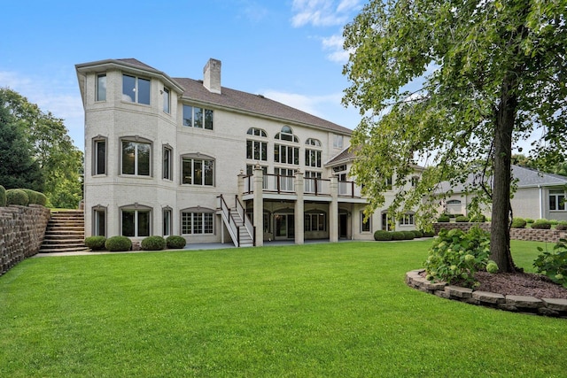 rear view of property featuring a lawn and a deck