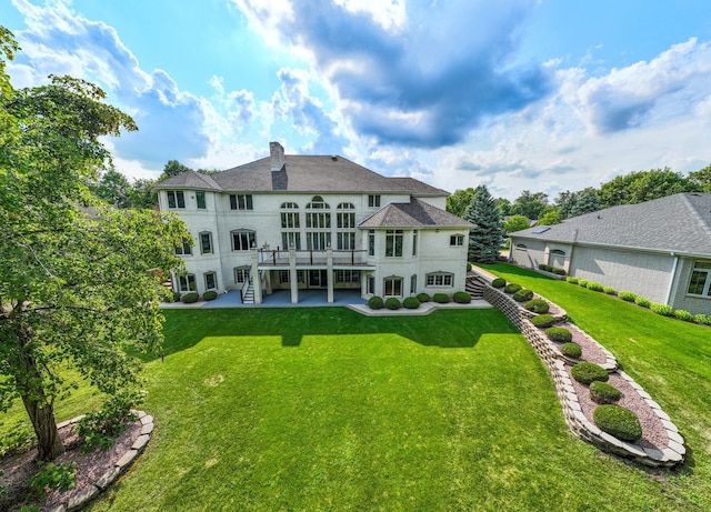 rear view of house with a deck and a lawn