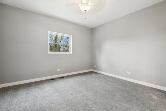 unfurnished room with ceiling fan and carpet