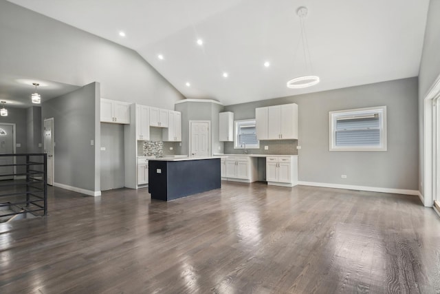 kitchen with tasteful backsplash, a center island, white cabinets, and hanging light fixtures